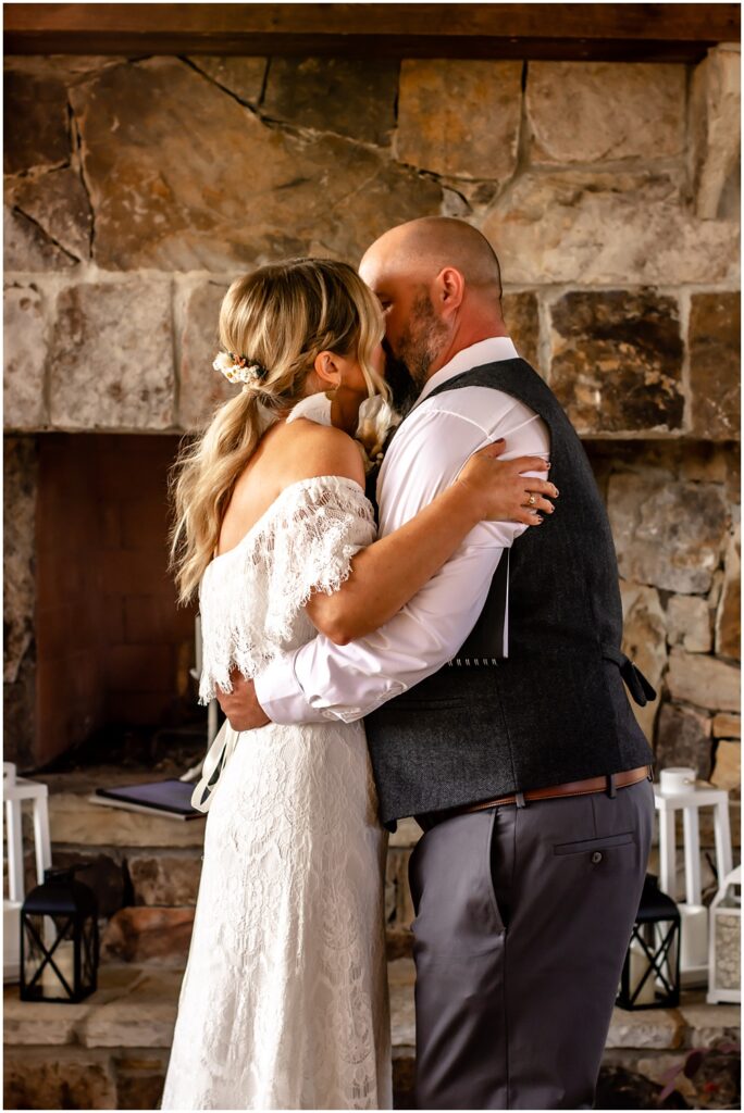 the bride and groom's first kiss as husband and wife during their wedding ceremony at sterling on the lake in flowery branch ga 