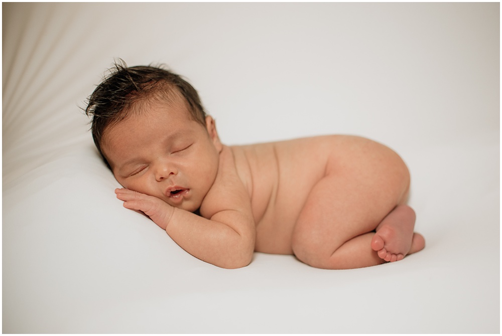 Flowery Branch photographer takes photo of the baby on the bean bag during the newborn session in the studio. He is snuggled tightly and sound asleep.