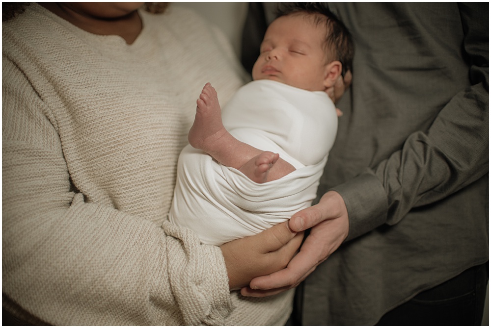 Flowery Branch photographer takes close up of baby boy and his parents during his newborn session in the studio