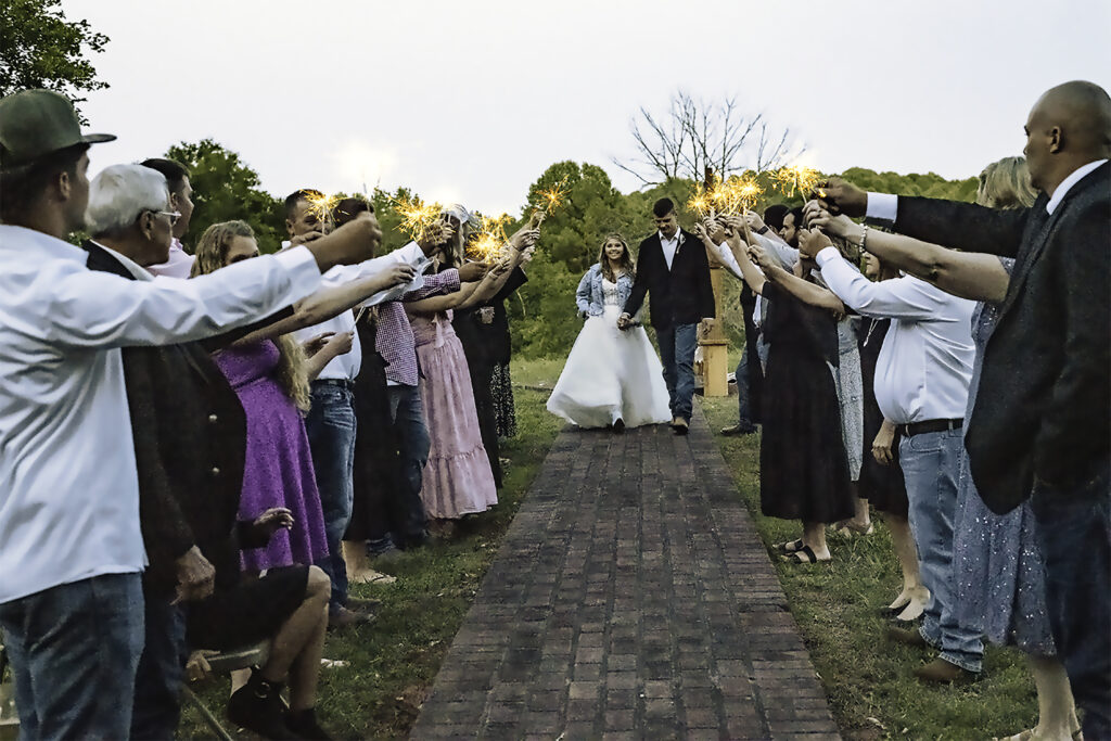 North Georgia photographer photographs a wedding in the country for a young couple in the north Georgia mountains. Photographed here is the Bride and Groom walking through their sparkler exit.