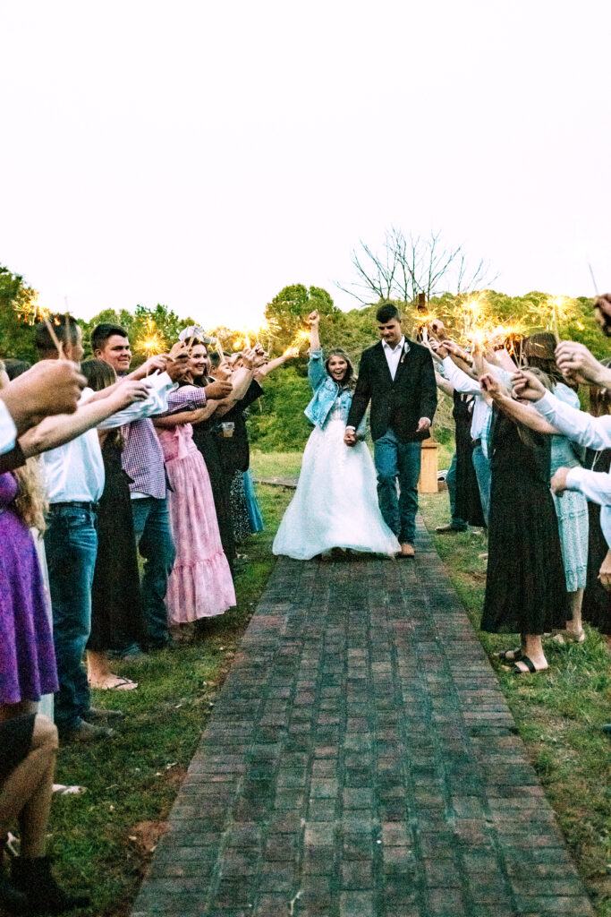 North Georgia photographer photographs a wedding in the country for a young couple in the north Georgia mountains. Photographed here is the Bride and Groom leaving, walking through sparklers. 