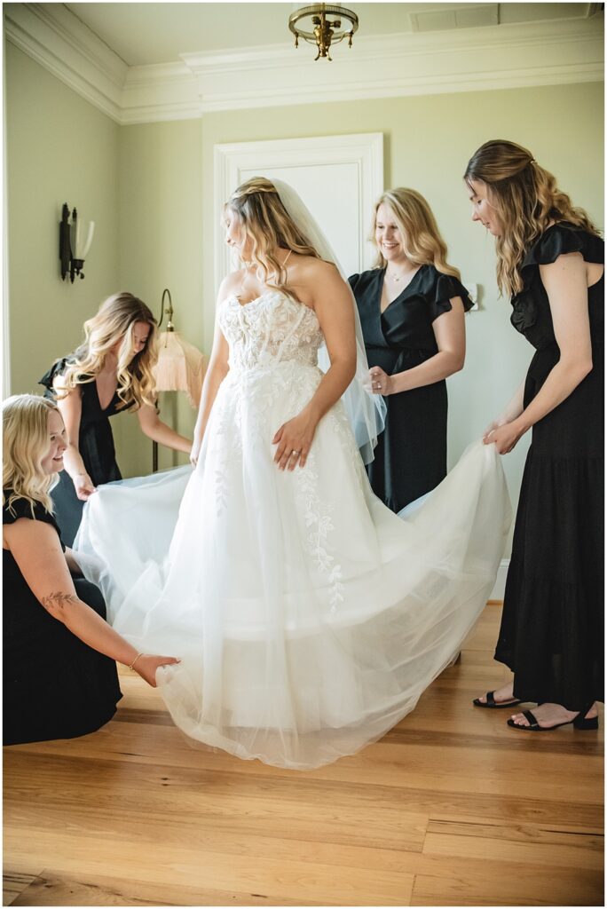 North Georgia photographer photographs the Bridesmaids fan out the Bride's dress